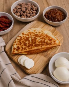 Crescione con salsiccia, cipolle caramellate, pomodori secchi e mozzarella – senza glutine e senza lattosio, Romagna Free — impiattato
